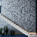 Elegant marble mosaic wall design paired with a minimalist staircase and indoor plants.