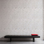 Minimalist design featuring a herringbone-patterned wall made of premium natural stone with a sleek black bench.