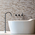 Elegant bathroom featuring a freestanding tub and light travertine blasted stone wall design.