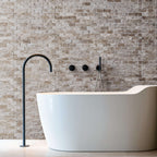 Elegant bathroom featuring a freestanding tub and light travertine blasted stone wall design.