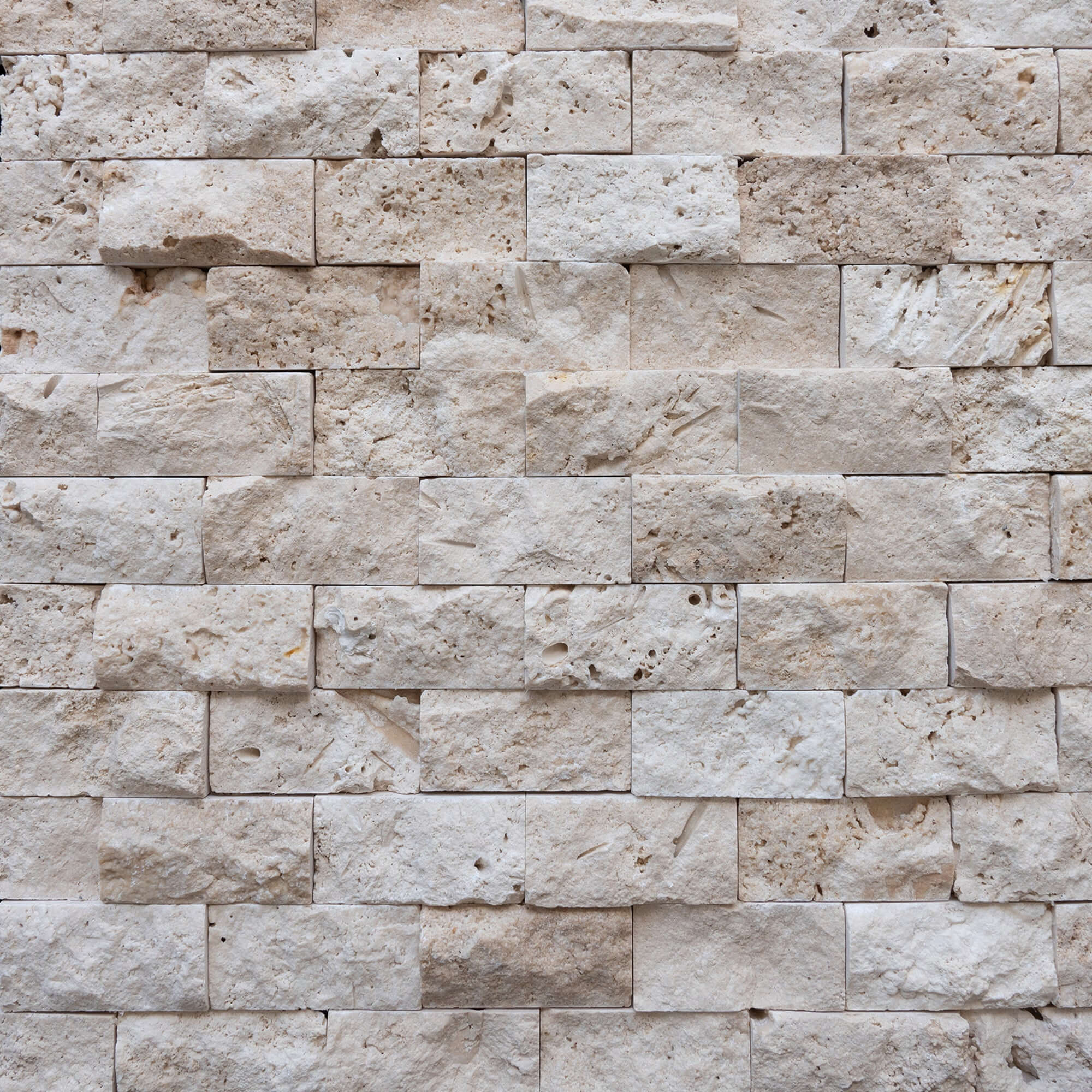 Blasted travertine wall tiles showcasing natural stone's elegant 3D texture, ideal for minimalist designs and vessel sinks.